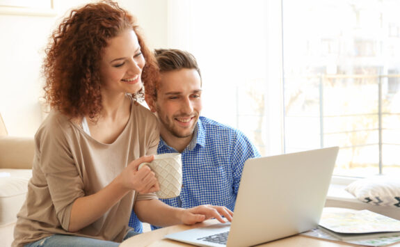 Happy young couple with laptop at home